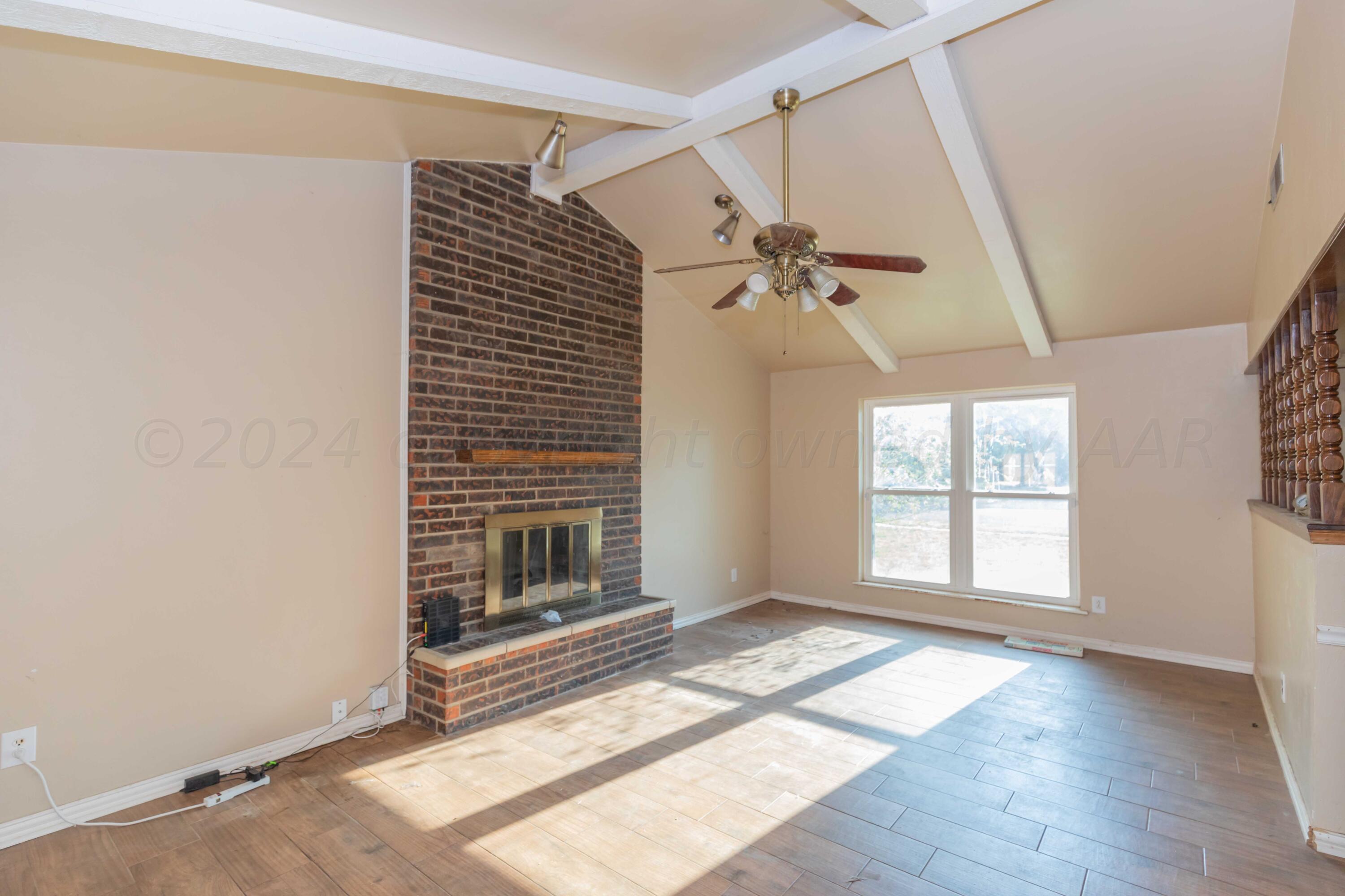 5304 Leigh Avenue Amarillo, TX 79110 - Photo 23 of 36 a view of an empty room with a window and wooden floor