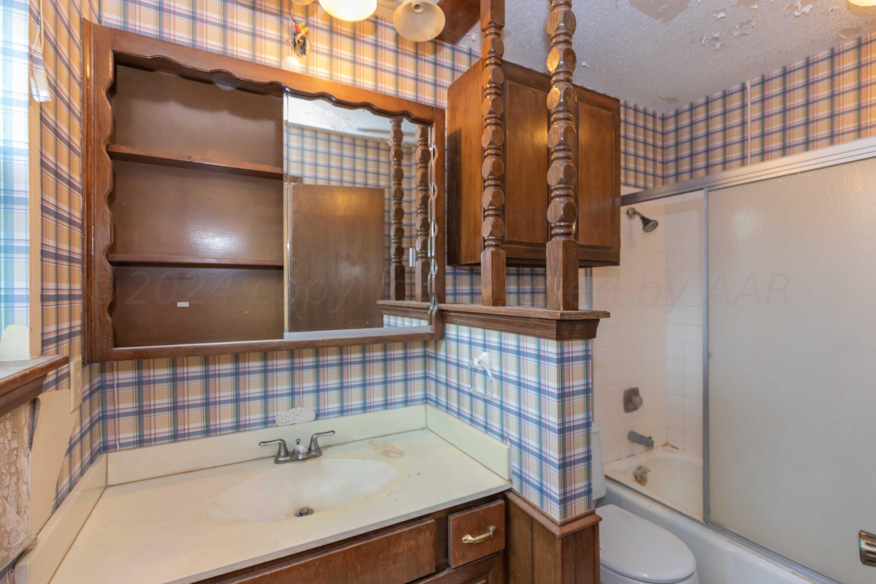 5304 Leigh Avenue Amarillo, TX 79110 - Photo 27 of 36 a bathroom with a sink and mirror