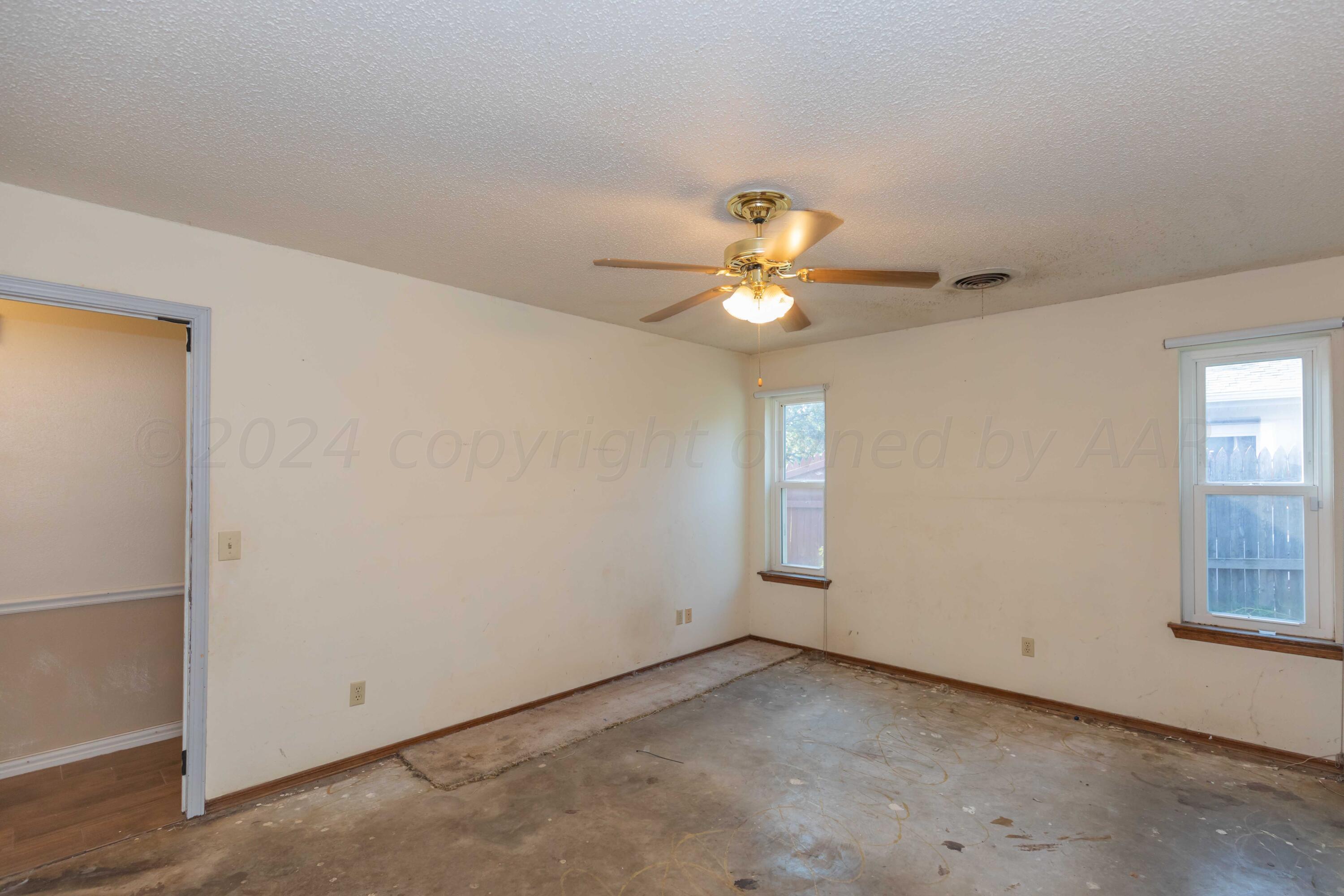 5304 Leigh Avenue Amarillo, TX 79110 - Photo 31 of 36 an empty room with a chandelier fan and windows