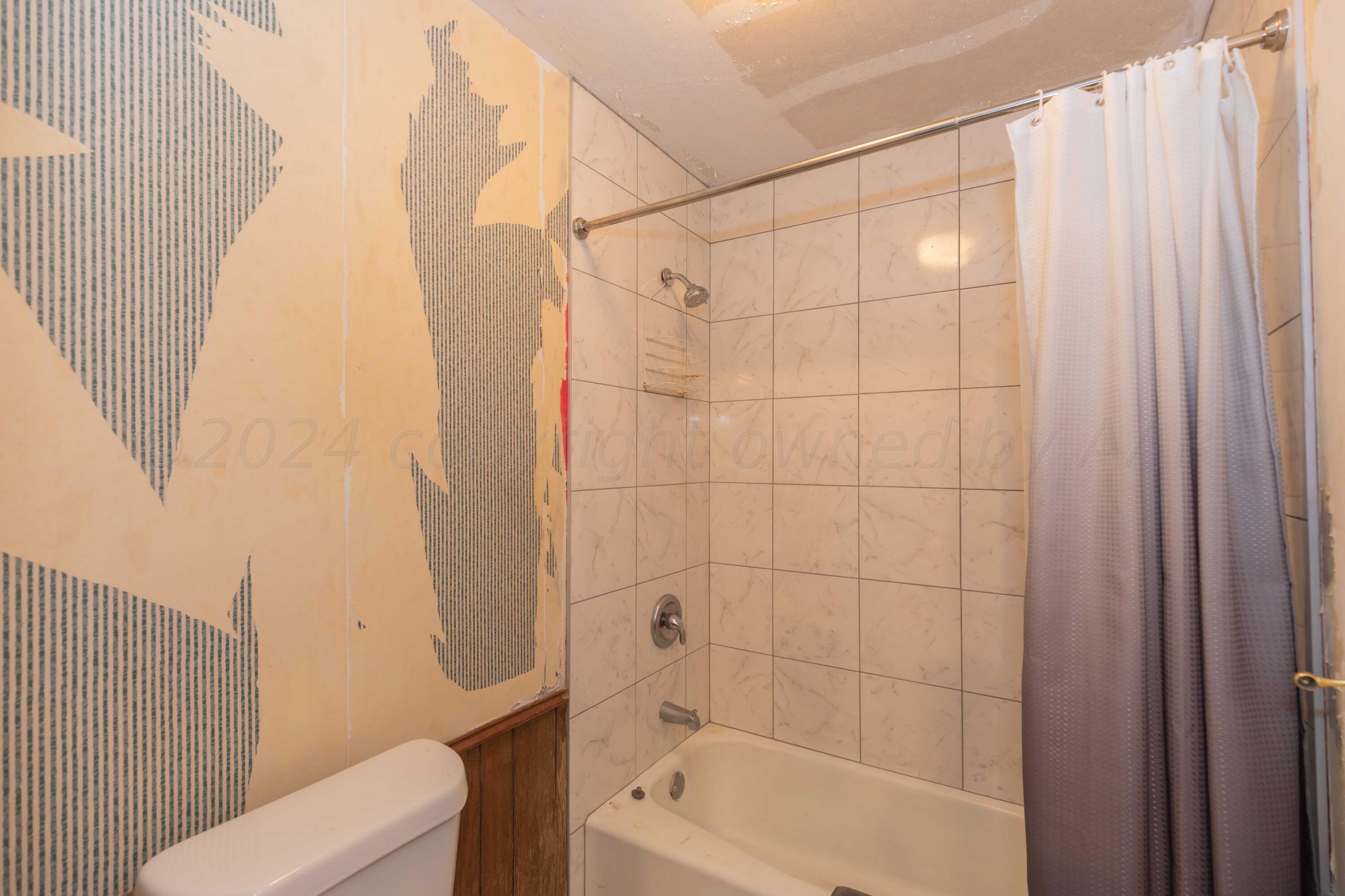 5304 Leigh Avenue Amarillo, TX 79110 - Photo 5 of 36 a bathroom with a shower curtain and a sink
