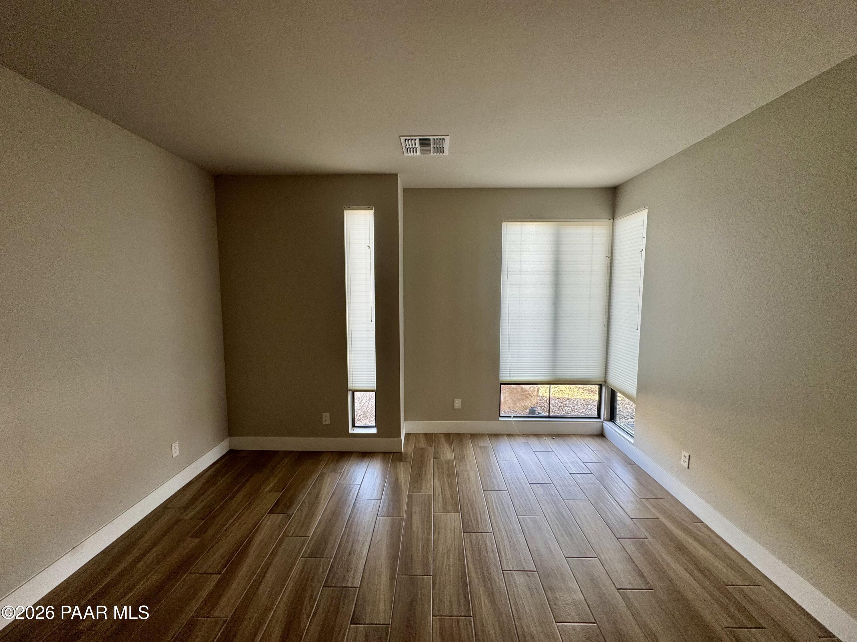 5556 East Killen Loop Prescott Valley, AZ 86314 - Photo 14 of 27 an empty room with wooden floor and windows
