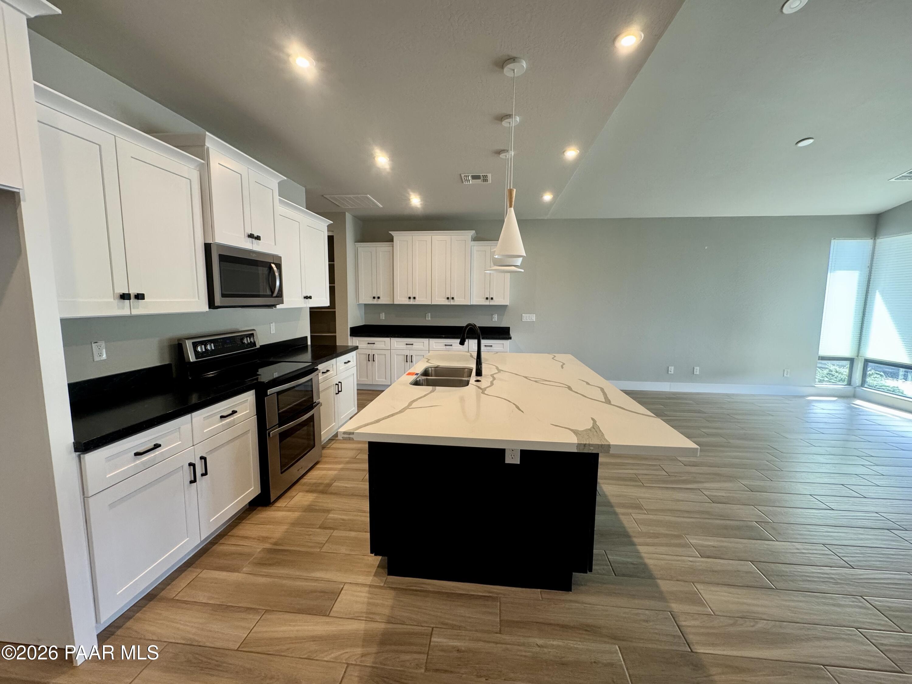 5556 East Killen Loop Prescott Valley, AZ 86314 - Photo 5 of 27 a kitchen with stainless steel appliances kitchen island granite countertop a sink and cabinets