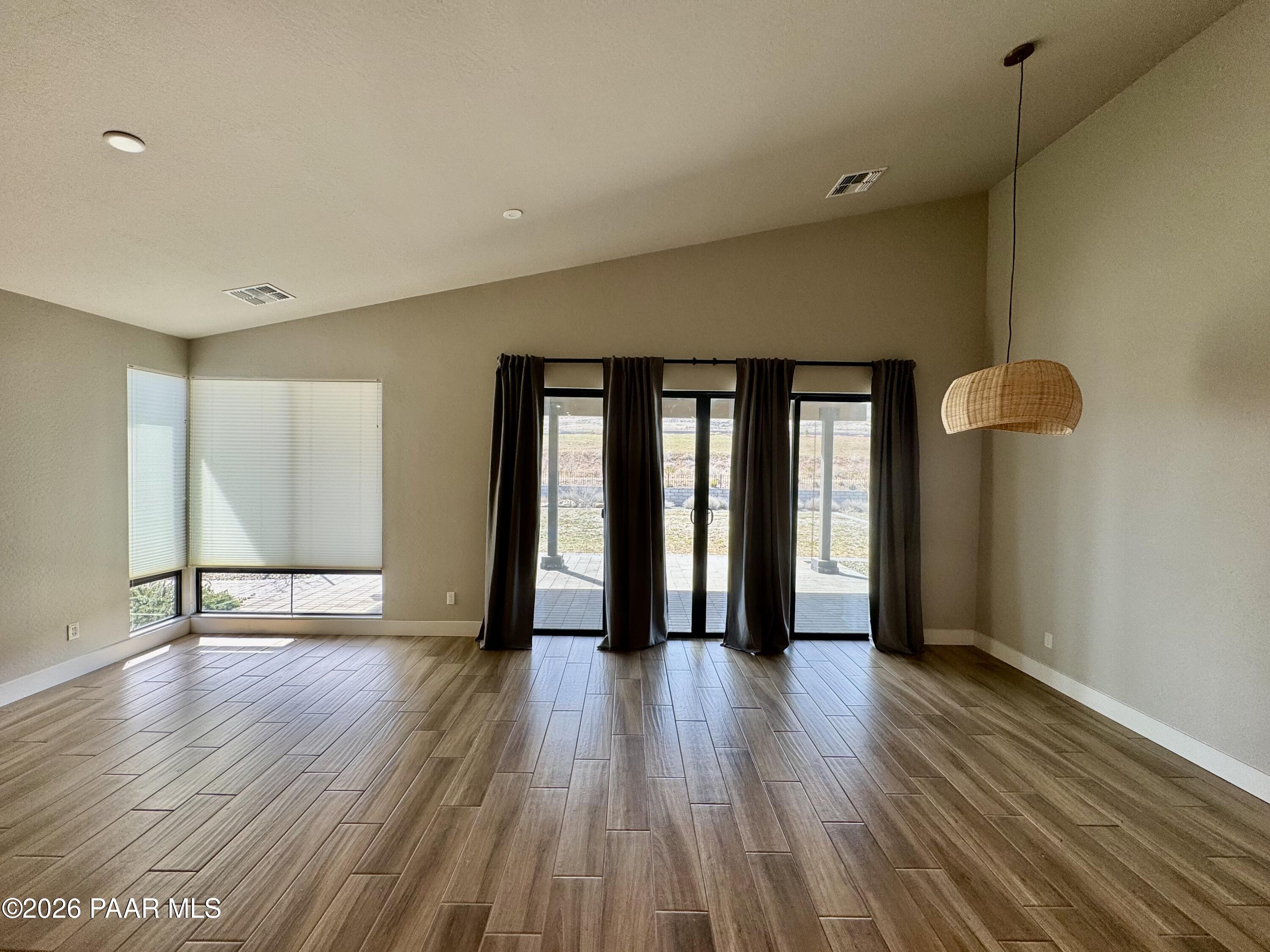 5556 East Killen Loop Prescott Valley, AZ 86314 - Photo 7 of 27 a view of an empty room with wooden floor and a window