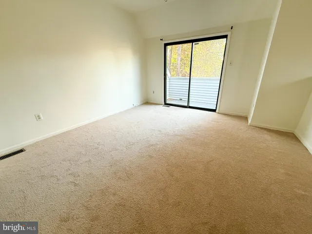 an empty room with a ceiling fan and a window