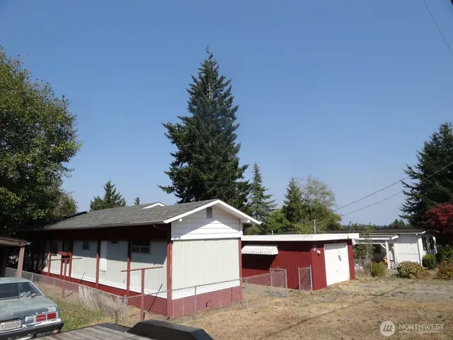 a front view of a house with yard garage and tree