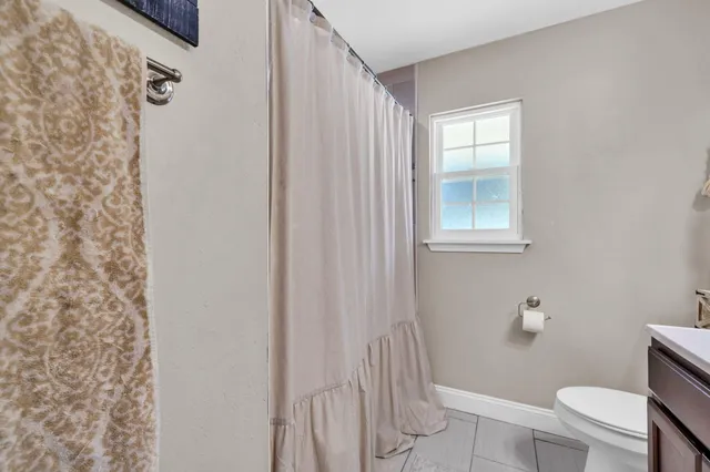 a bedroom with a bed a desk and chair with white walls