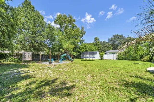 an aerial view of residential houses with outdoor space and trees