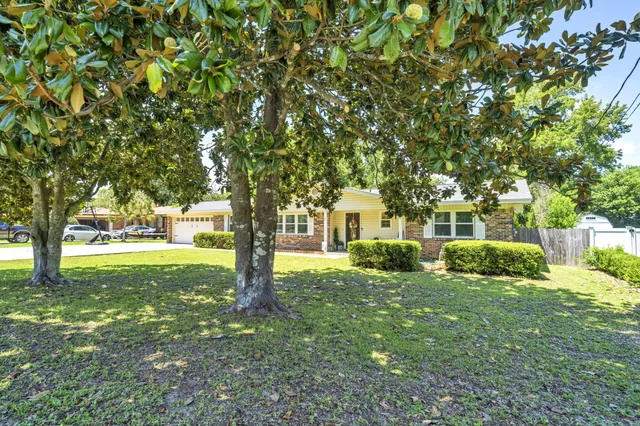an aerial view of residential houses with outdoor space and trees