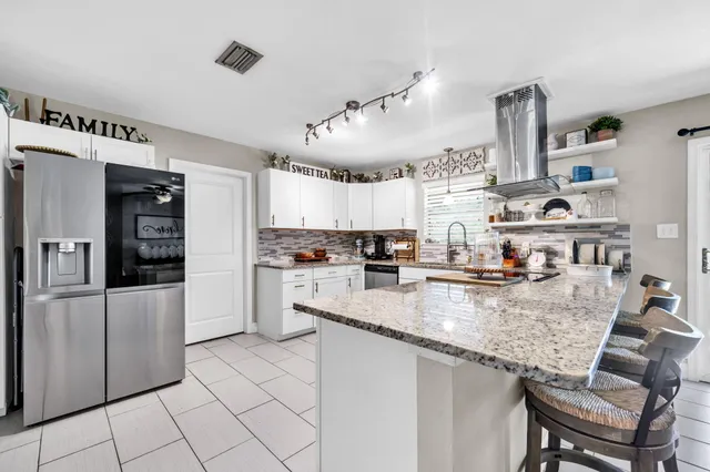 a kitchen with cabinets and chairs