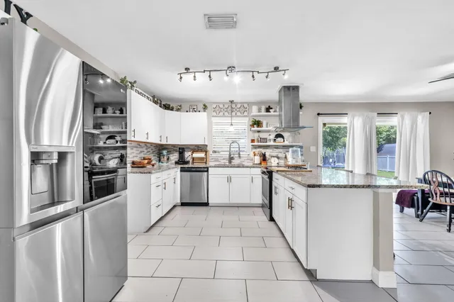 a kitchen with sink a stove and chairs
