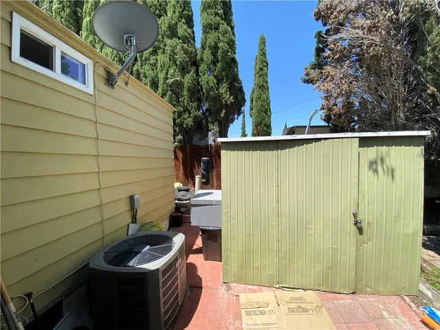 a backyard of a house with chairs and potted plants