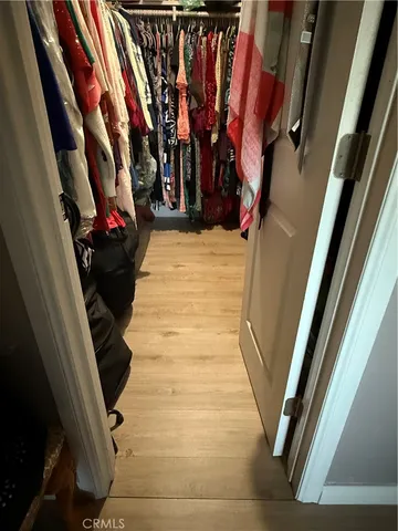 a view of walk in closet with clothes