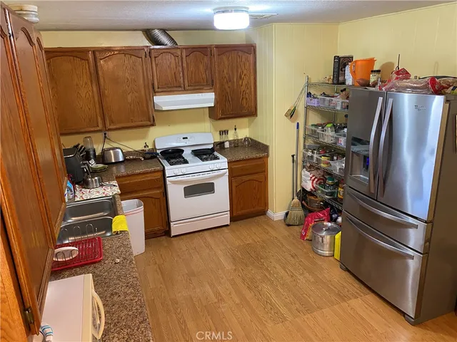 a kitchen with stainless steel appliances a stove a refrigerator and a wooden cabinets