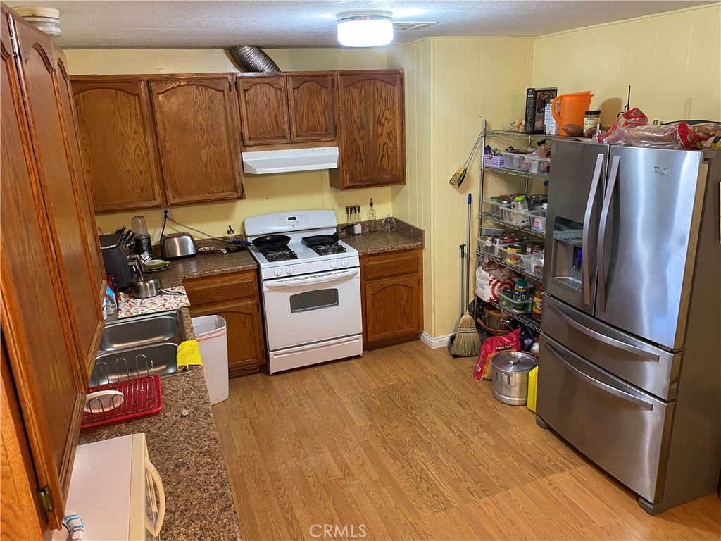 995 Pomona Road, Unit 41 Corona, CA 92882 - Photo 10 of 12 a kitchen with stainless steel appliances a stove a refrigerator and a wooden cabinets