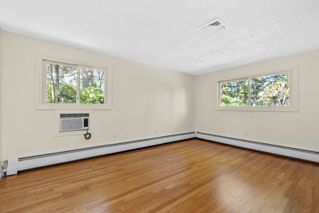 1704 Trapelo Road Waltham, MA 02451 - Photo 12 of 16 an empty room with wooden floor and windows