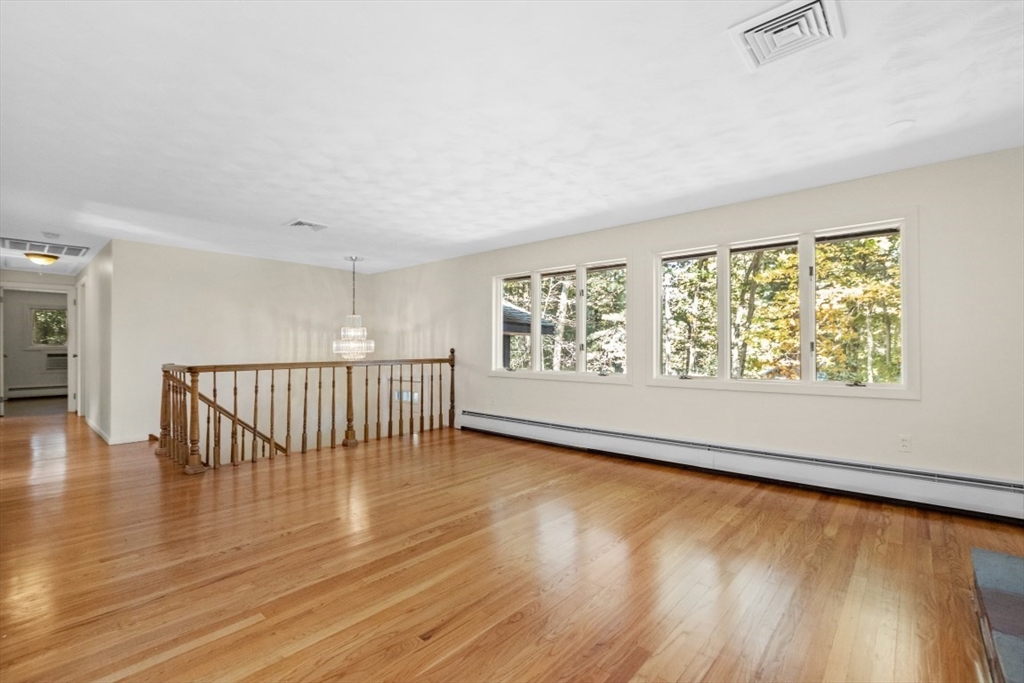 1704 Trapelo Road Waltham, MA 02451 - Photo 4 of 16 an empty room with wooden floor and windows