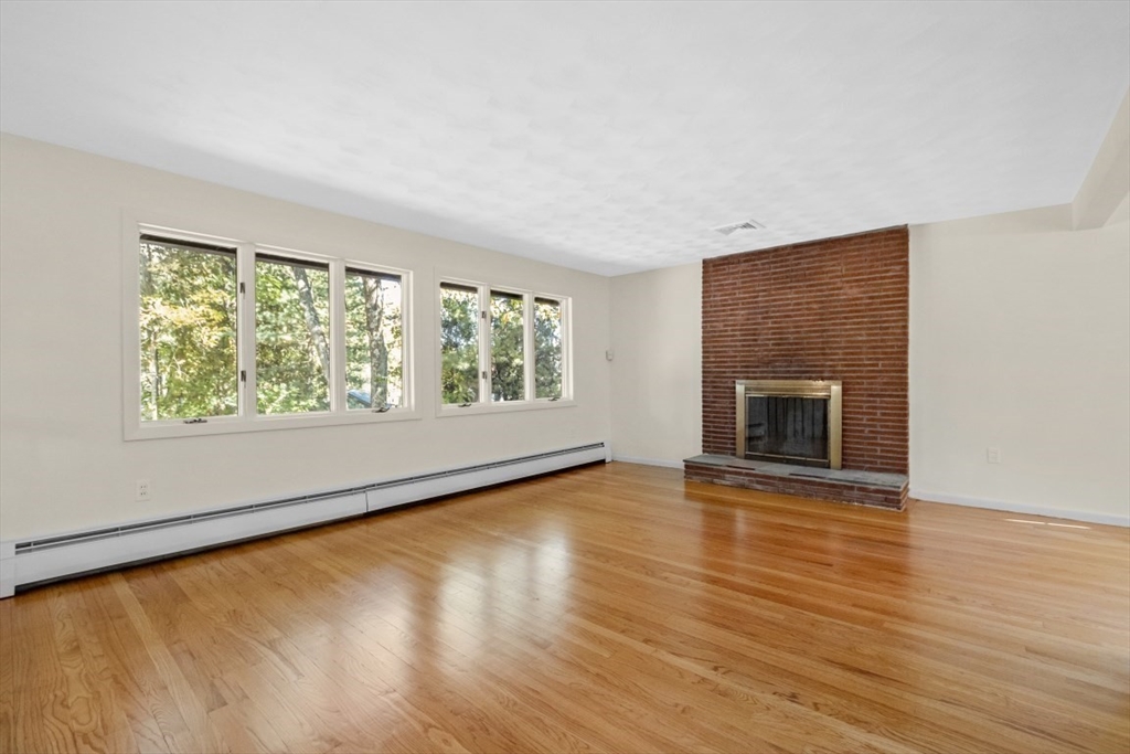 1704 Trapelo Road Waltham, MA 02451 - Photo 6 of 16 a view of an empty room with wooden floor and a window