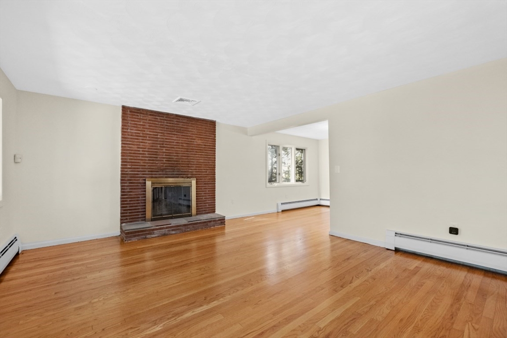 1704 Trapelo Road Waltham, MA 02451 - Photo 7 of 16 a view of an empty room with wooden floor and a window