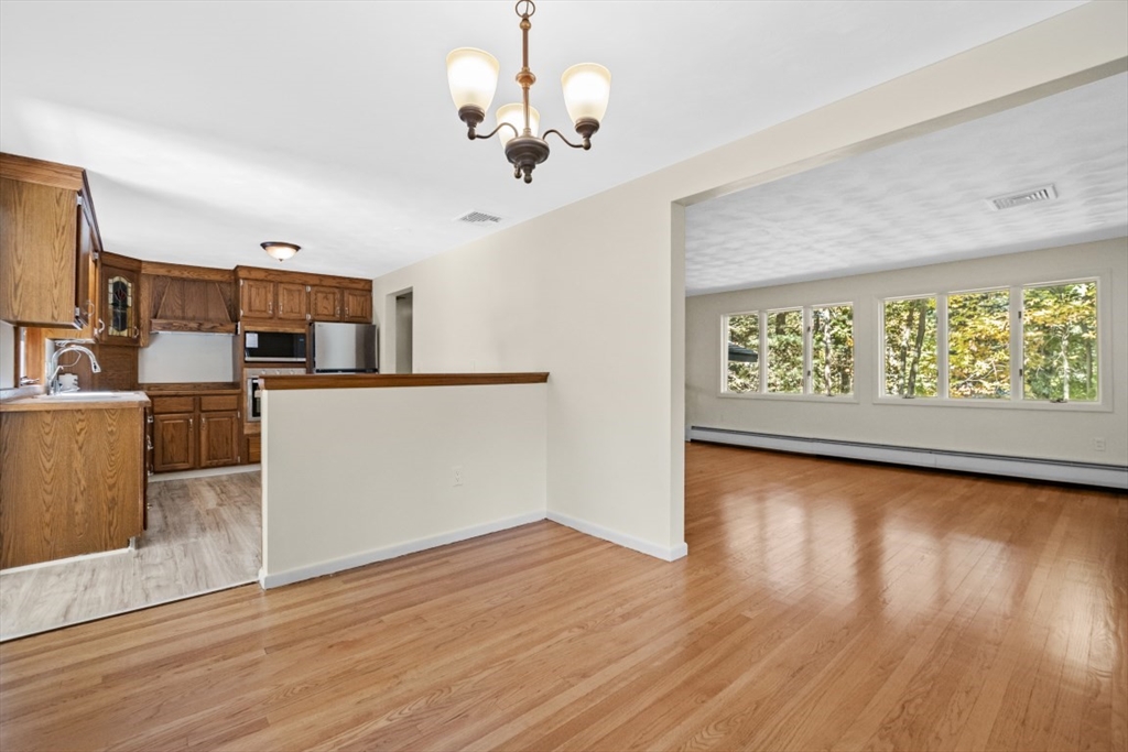 1704 Trapelo Road Waltham, MA 02451 - Photo 8 of 16 a view of a kitchen with wooden floor and a ceiling fan