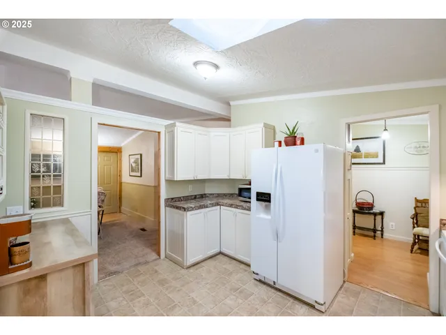 a kitchen with kitchen island a sink a refrigerator and cabinets