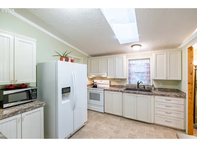a kitchen with stainless steel appliances a sink stove and window