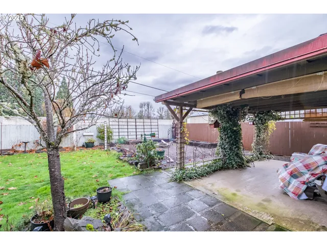a view of a grey house with a sink and a yard