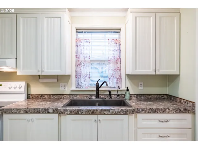 a kitchen with stainless steel appliances a refrigerator and a view of living room