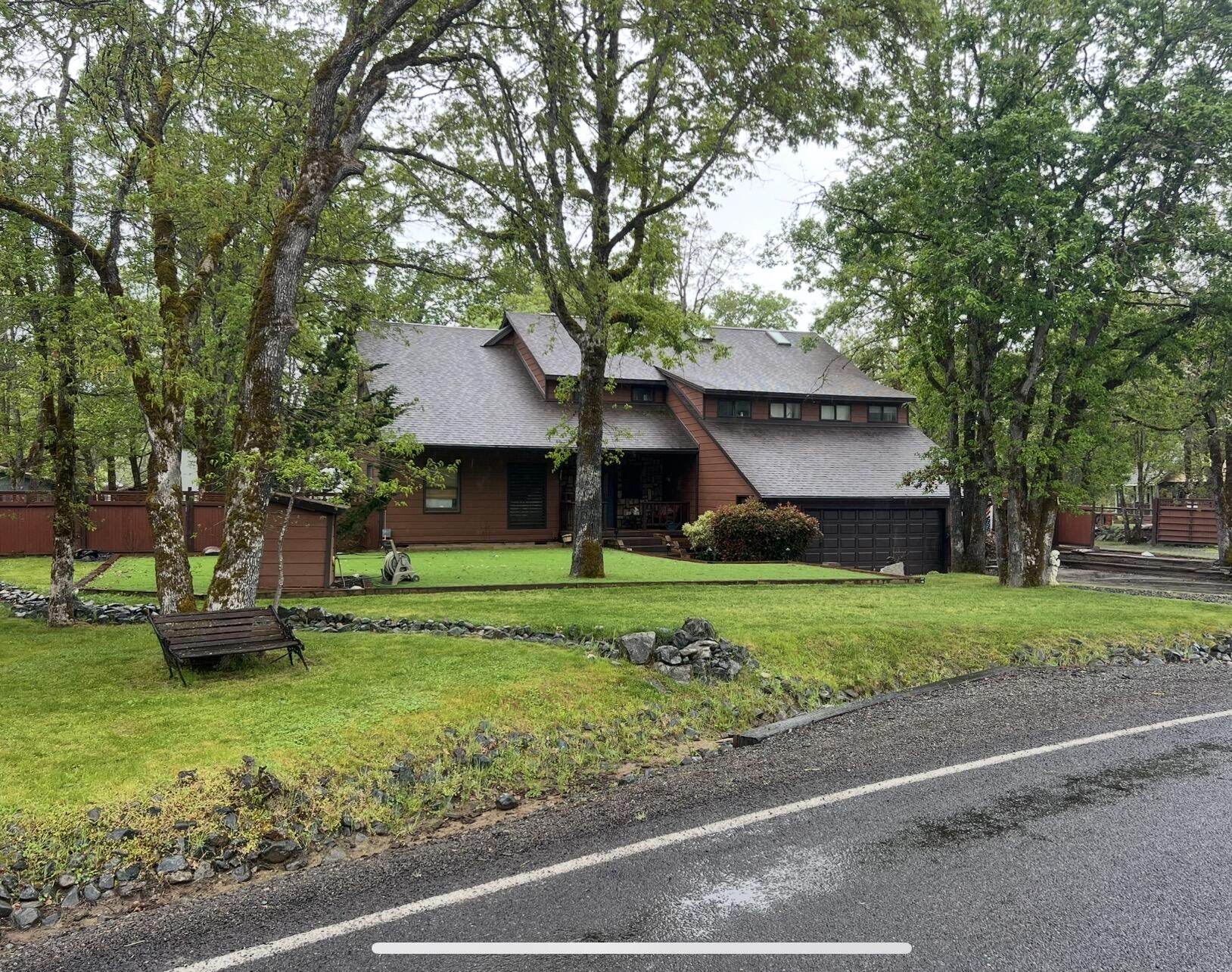 255 Barker Drive Merlin, OR 97532 - Photo 1 of 26 a front view of a house with a garden and trees