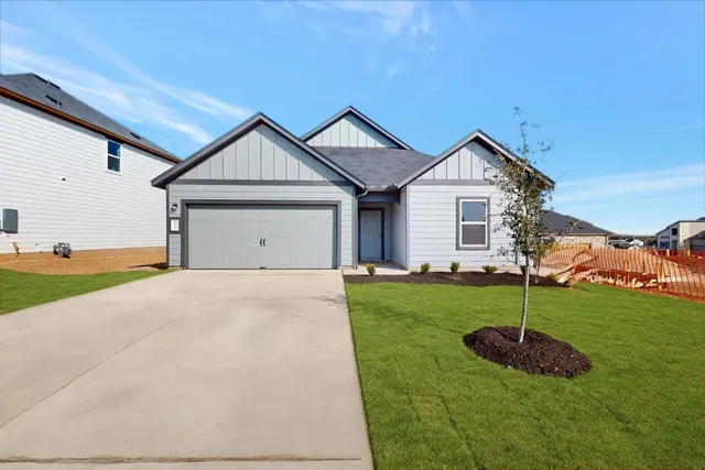 a view of a house with a yard and potted plants