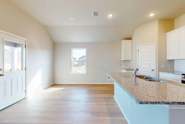 a large kitchen with kitchen island granite countertop a sink window and refrigerator