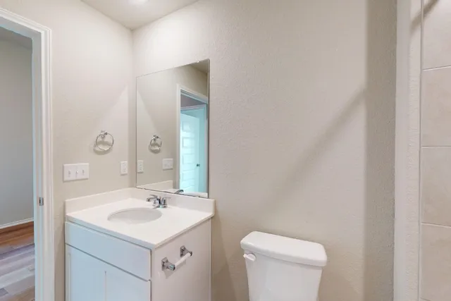 a bathroom with a sink toilet and mirror