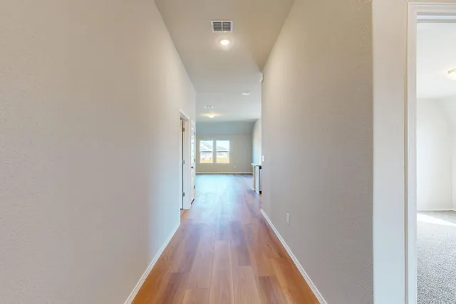 a view of a hallway with wooden floor