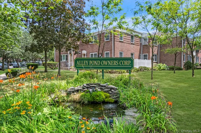 a view of a park that has a sign board large trees