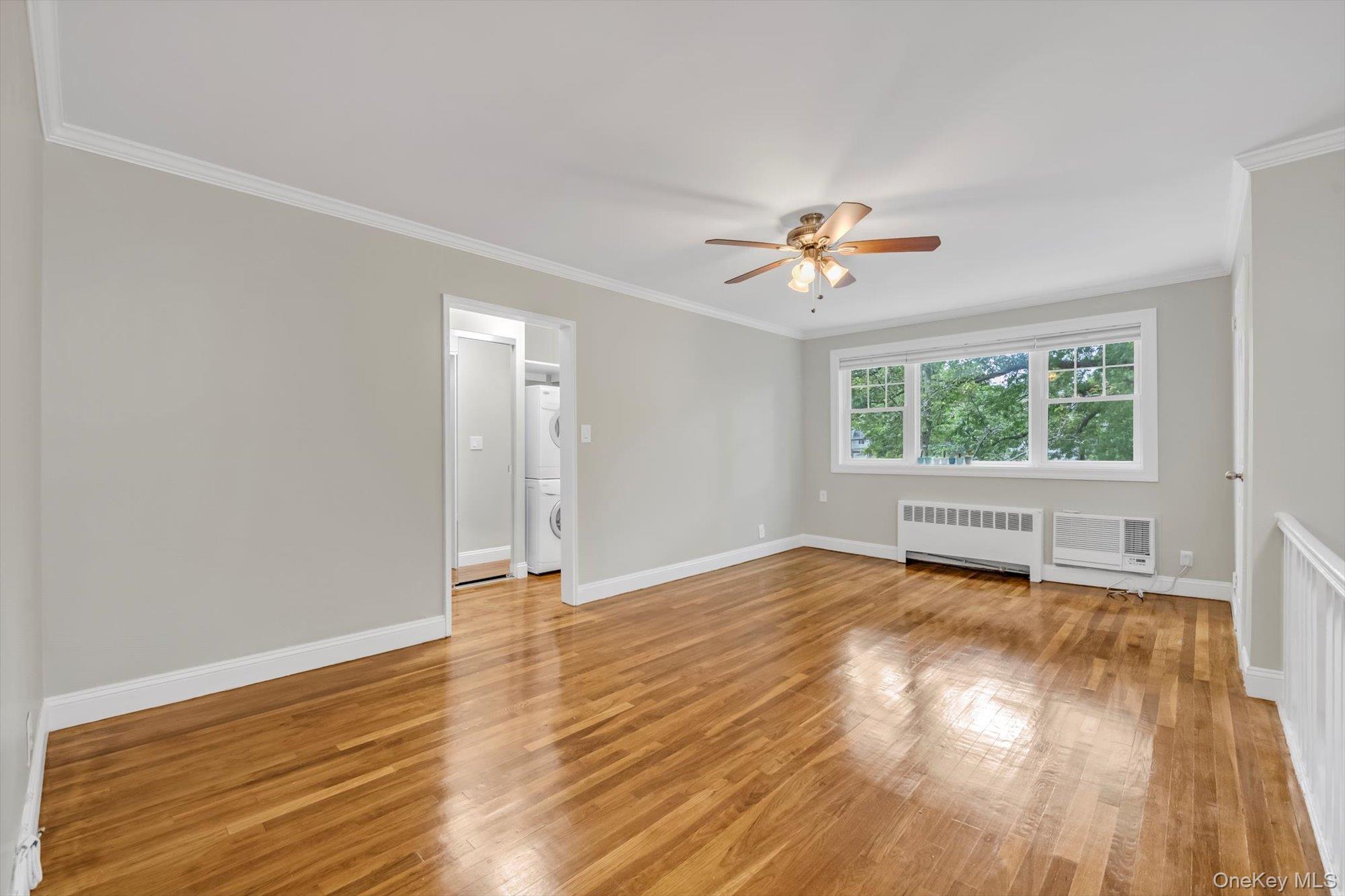 77-17 Springfield Boulevard, Unit B Queens, NY 11364 - Photo 4 of 11 an empty room with wooden floor and windows