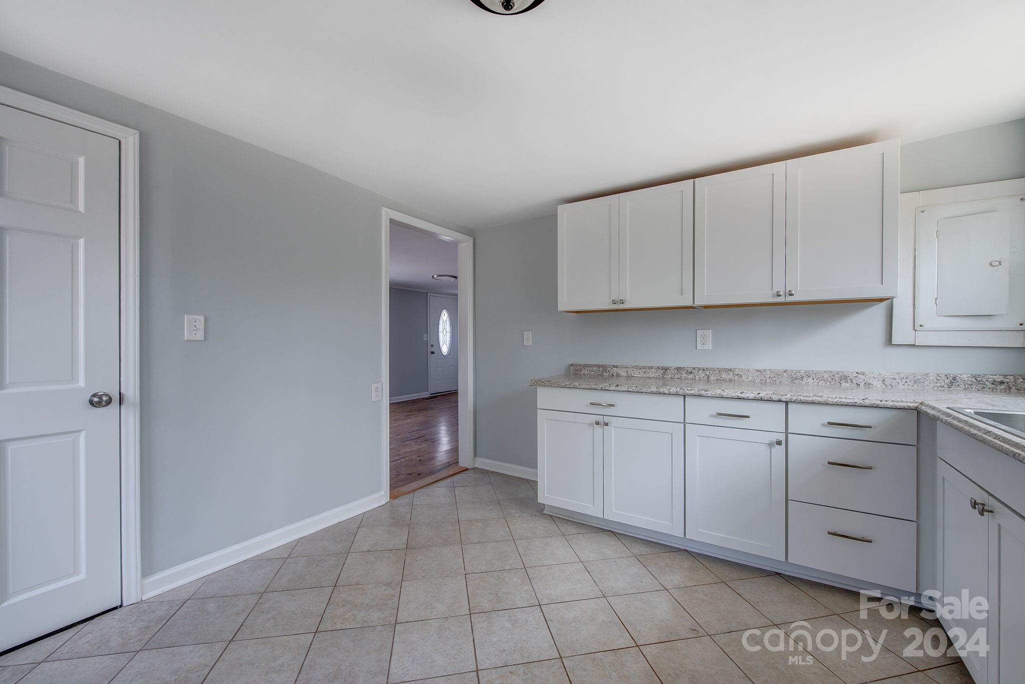 2714 Rufus Ratchford Road Gastonia, NC 28056 - Photo 7 of 28 a kitchen with granite countertop white cabinets and stainless steel appliances