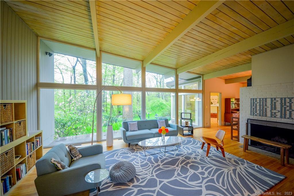 87 Larkspur Road Stamford, CT 06903 - Photo 1 of 1 a living room with furniture a flat screen tv and a floor to ceiling window