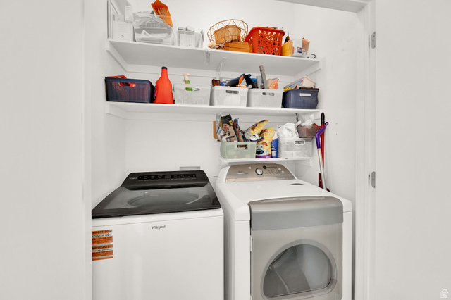 7713 Navarro View Court Midvale, UT 84047 - Photo 13 of 41 Laundry closet featuring a top-load washing machine, front-load dryer, and multiple overhead shelving units