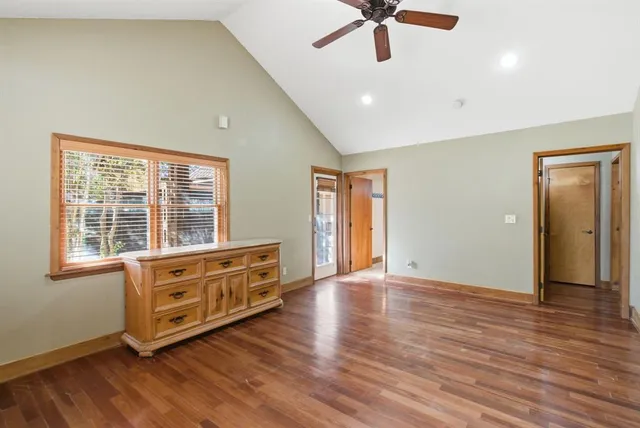 a view of an empty room with window and wooden floor