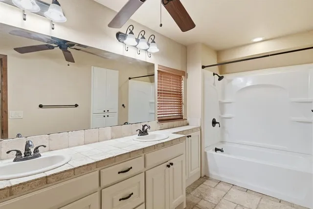 a bathroom with a double vanity sink mirror double and bathtub