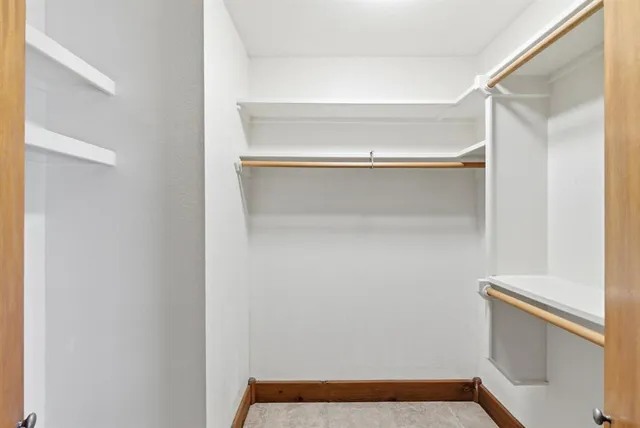 a view of walk in closet with empty racks