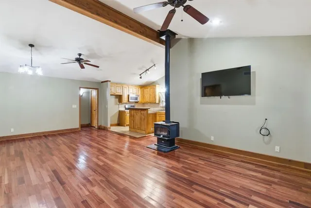 a view of a livingroom with a flat screen tv wooden floor and a ceiling fan