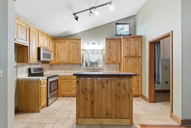 a kitchen with stainless steel appliances granite countertop a refrigerator and microwave