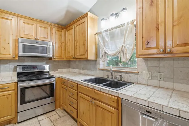 a kitchen with a sink stove and microwave