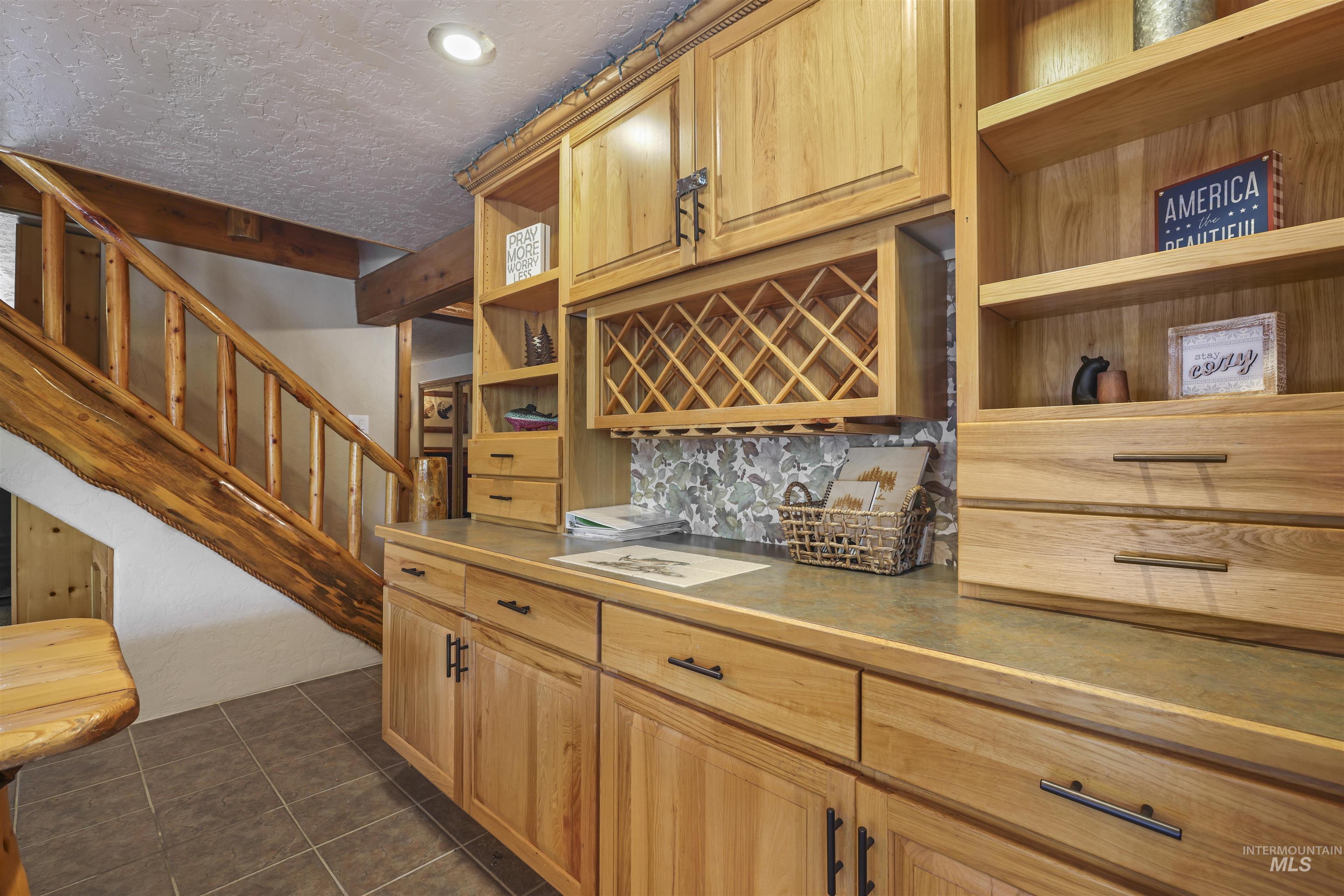 224 Dakota Road Mountain Home, ID 83647 - Photo 13 of 50 Custom wood cabinetry with integrated wine rack, stone mosaic backsplash, and contrasting countertops