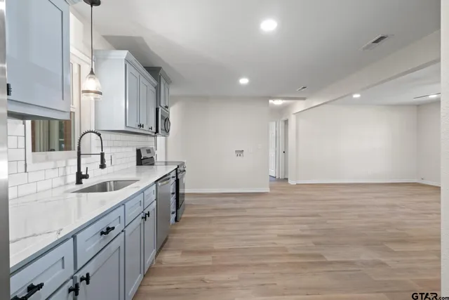a kitchen with stainless steel appliances a sink stove and cabinets
