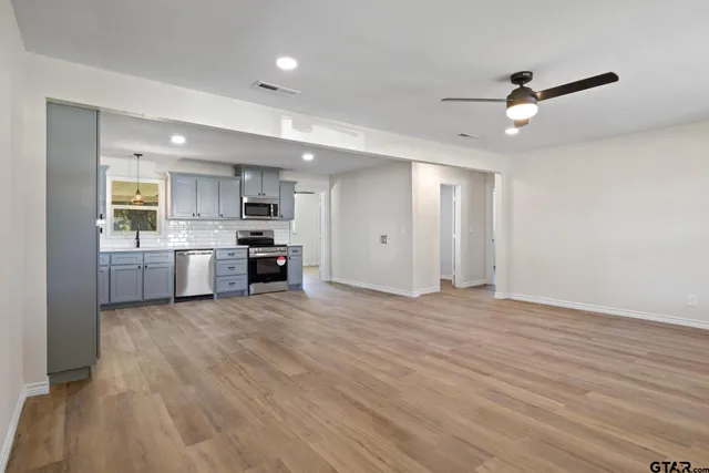a view of a kitchen with a sink and dishwasher a oven with wooden floor