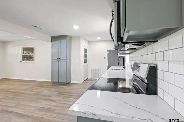 a view of an empty room with wooden floor