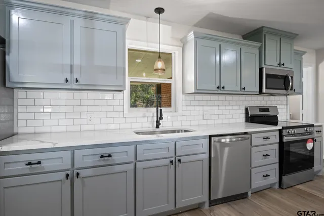 a kitchen with a sink cabinets and stainless steel appliances