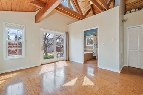 a view of a hallway with wooden floor and a large window