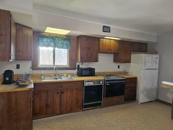 a kitchen with stainless steel appliances granite countertop a stove a sink dishwasher and a refrigerator